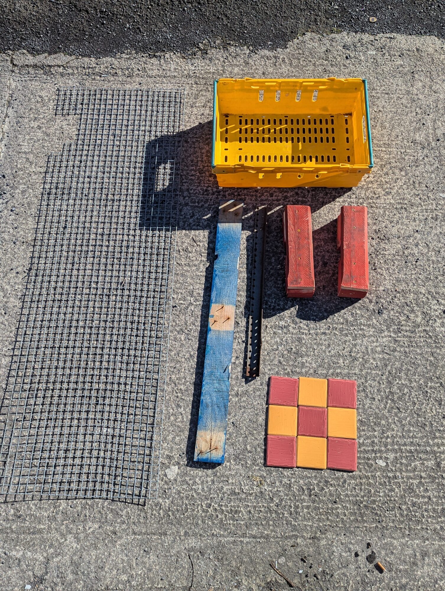 Flat-lay of all the scrap before assembly: grate, crate, pallet wood, tiles